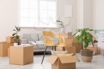 Cardboard boxes with belongings and furniture in new flat on moving day�