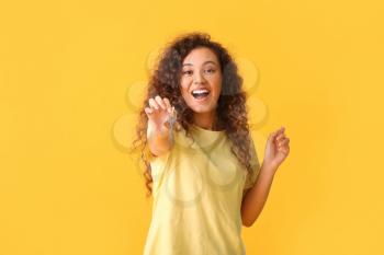 Happy young woman with key on color background�