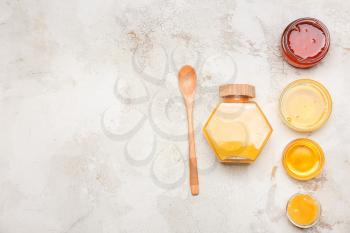 Assortment of tasty honey on grey background�