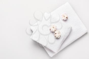 Cotton flowers and soft towels on grey background�