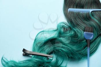 Unusual wig with hairdresser supplies on color background�