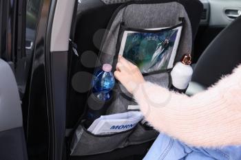 Woman using tablet computer in salon of car�