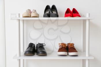 Stand with stylish shoes in interior of modern hall�