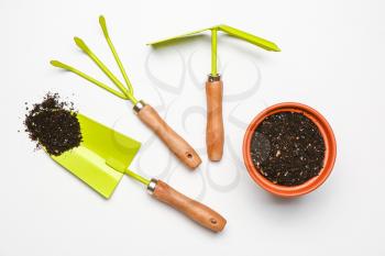 Set of gardening supplies with soil on white background�