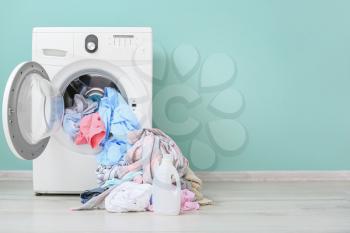 Washing machine with dirty clothes and detergent in home laundry room�