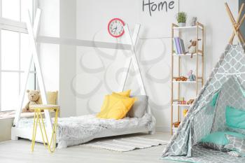 Interior of modern children's room with play tent and bed�
