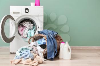 Washing machine with dirty clothes near color wall�