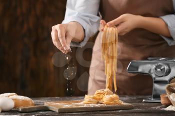 Woman preparing pasta in kitchen, closeup�