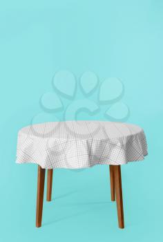 Dining table with tablecloth on color background�