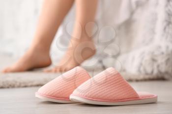 Pair of soft slippers on floor in bedroom�