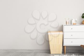 Basket and chest of drawers with cosmetics in bathroom�