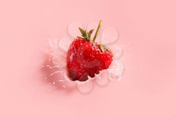 Falling of fresh strawberry into milk�