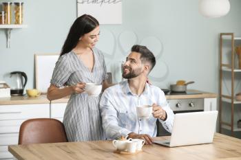 Happy young couple drinking tea at home�