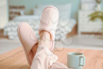 Young woman in soft slippers at home�