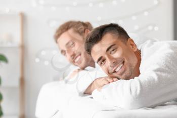 Happy gay couple relaxing in spa salon�