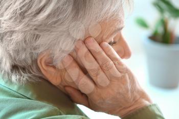 Senior woman suffering from headache at home�