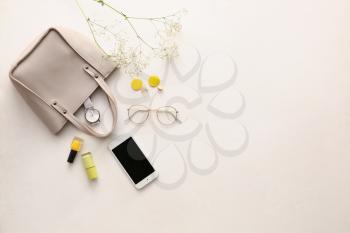 Stylish bag, accessories and mobile phone on light background�