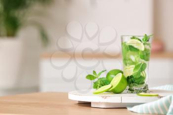 Glass of fresh mojito on table in kitchen�
