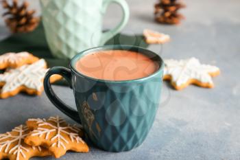 Cup of hot cacao drink with cookies on color background�