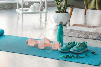 Sports equipment on yoga mat at home�
