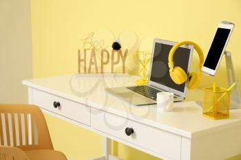 Stylish workplace with modern gadgets in room�