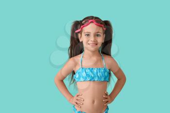 Little girl in swimsuit on color background�