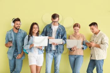 Students with modern devices near color wall�