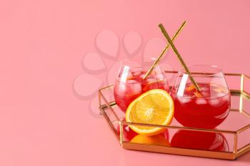Tray with glasses of fruit ice tea on color background�