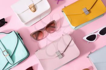 Composition with sunglasses and bags on color background�