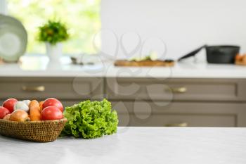 Basket with vegetables on table in modern kitchen�