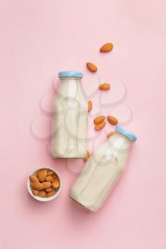Bottles of tasty almond milk on color background�