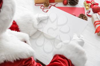 Santa Claus with empty letter at table�