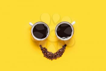Creative composition with cups and coffee beans on color background�