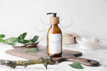 Bottle with natural shampoo on light background�