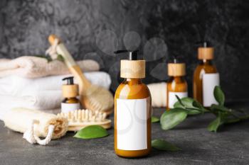 Bottles with natural shampoo on dark background�