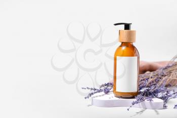 Bottle of natural shampoo and lavender flowers on white background�