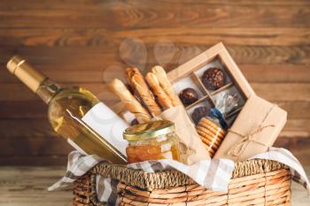 Gift basket with products on wooden background�