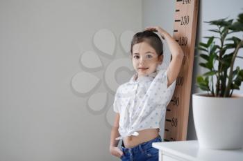 Little girl measuring height at home�