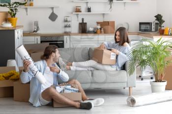 Young couple with cardboard boxes in their new house on moving day�