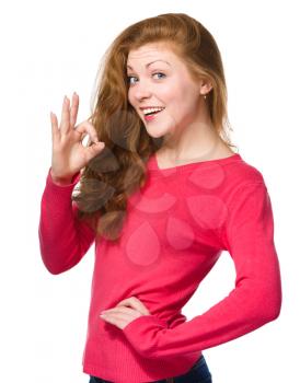 Young woman is showing OK sign, isolated over white