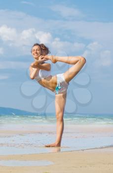 Royalty Free Photo of a Woman Doing Yoga on the Beach