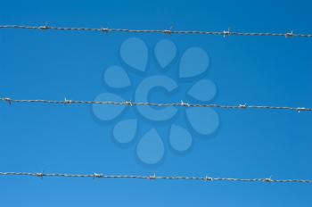 image of a barbed wire against the blue sky
