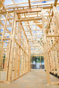 New residential construction home framing against a blue sky