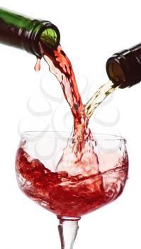 white and red wine  being poured into a wine glass isolated on white
