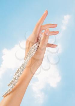 image of beautiful nails and woman fingers with pearls