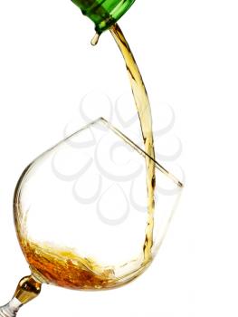 Brandy being poured from  bottle to the glass isolated on white 