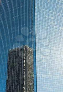 Abstract view of glass facade office modern building with reflection of other building
