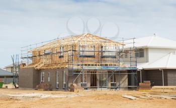 Construction site with the house in scaffolding against a blue sky