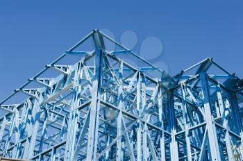 New residential construction home metal framing against a blue sky