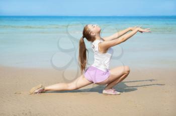 Attractive young woman doing exercise on the Beach